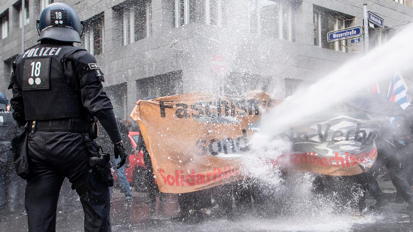 Ein Wasserwerfer spritzt Wasser gegen Demonstranten: Die linken Aktivisten hatten die Route der "Querdenker" blockiert und sich geweigert, den Weg freizumachen.
