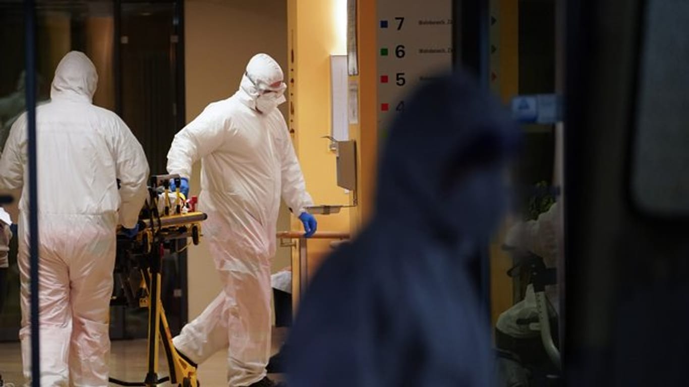 Sanitäter schieben in einem Seniorendomizil im Stadtteil Lichtenberg eine Tragbahre.
