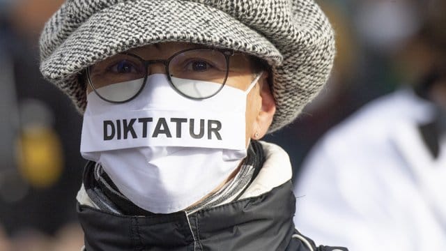 "Diktatur" steht auf der Nase-Mund-Bedeckung" einer Teilnehmerin an einer "Querdenken"-Demonstration in Frankfurt am Main.