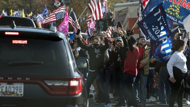 Der US-Präsident Trump fährt in einer Autokolonne an einer Gruppe von Anhängern vorbei, die zu dessen Unterstützung und gegen angeblich gefälschte Wahlergebnisse in der Nähe des Weißen Hauses demonstrieren.