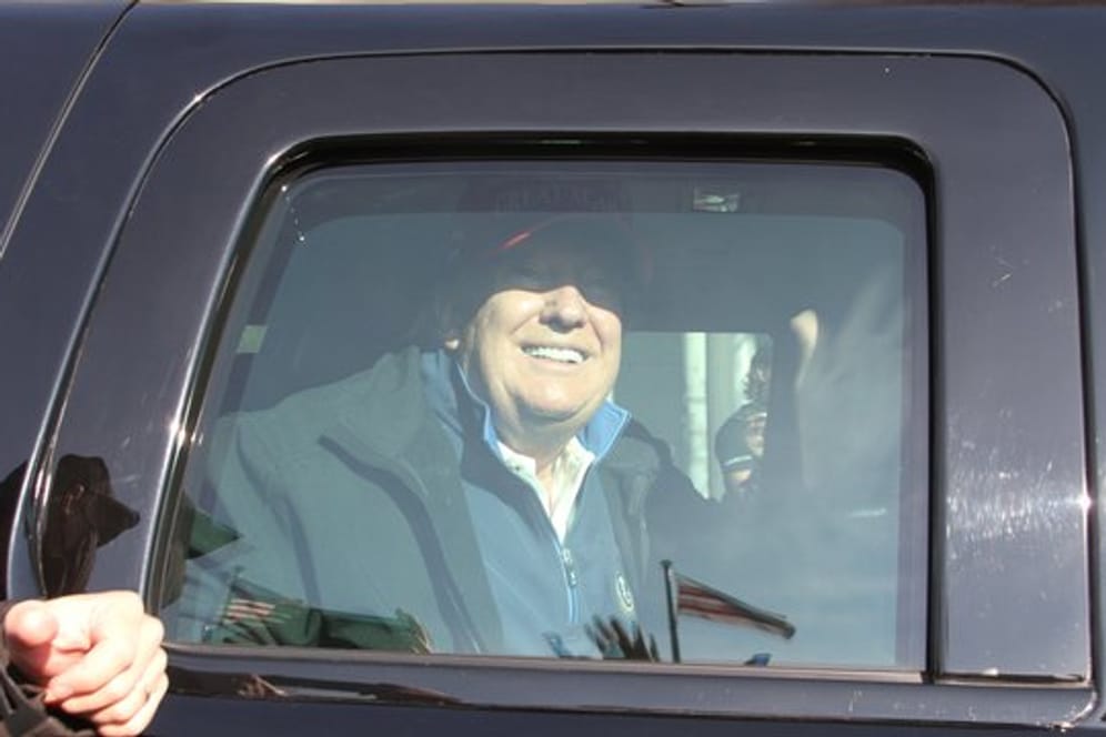 Donald Trump, Präsident der USA, lächelt aus einem Auto Demonstranten zu.