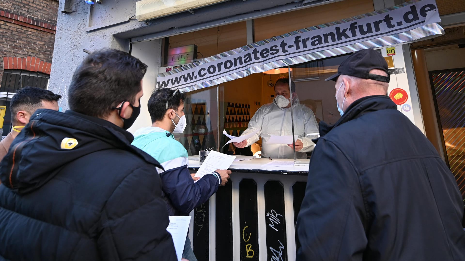 Passanten stehen vor einem Kiosk im Stadtteil Bockenheim, in dem der Internist Georg Siemon einen Corona-Schnelltest anbietet: Der Arzt nutzt den Kiosk nach dessen Schließung für sein privat-ärztliches Testzentrum. Passanten stehen vor einem Kiosk im Stadtteil Bockenheim, in dem der Internist Georg Siemon einen Corona-Schnelltest anbietet: Der Arzt nutzt den Kiosk nach dessen Schließung für sein privat-ärztliches Testzentrum.