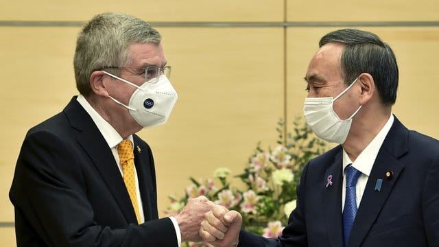 Thomas Bach (l), Präsident des Internationalen Olympischen Komitees, und Yoshihide Suga, Premierminister von Japan, begrüßen sich. Thomas Bach (l), Präsident des Internationalen Olympischen Komitees, und Yoshihide Suga, Premierminister von Japan, begrüßen sich.