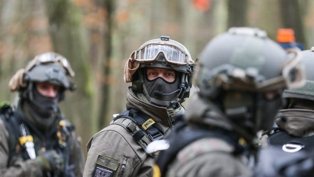 Polizisten mit Schutzausrüstung nehmen an einem Großeinsatz im Dannenröder Forst teil.