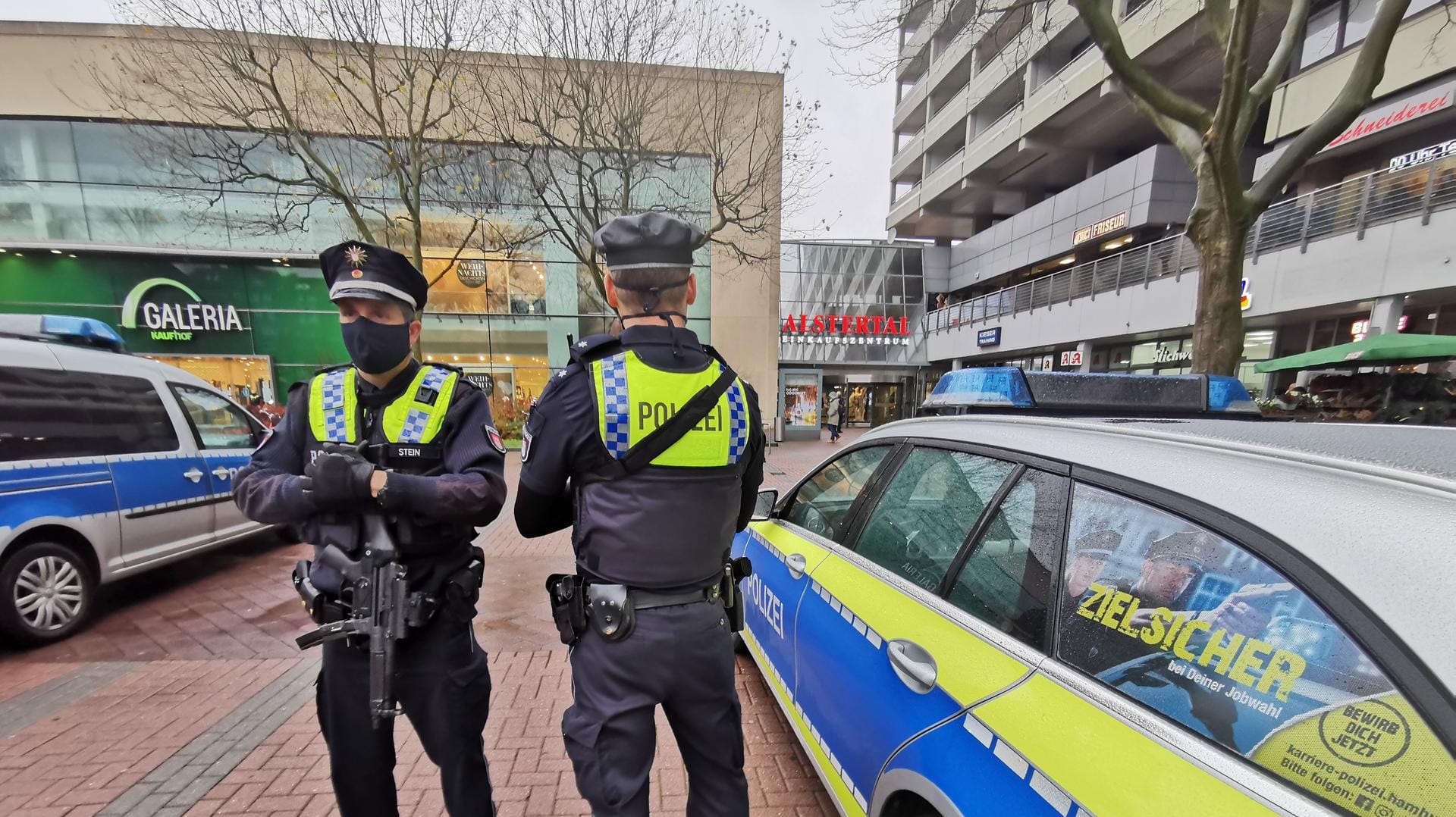 Einsatzkräfte der Polizei stehen vor einem Eingang des Alstertal-Einkaufszentrums (AEZ) in Hamburg: Dort war angeblich eine Person mit Waffe gesehen worden. Einsatzkräfte der Polizei stehen vor einem Eingang des Alstertal-Einkaufszentrums (AEZ) in Hamburg: Dort war angeblich eine Person mit Waffe gesehen worden.