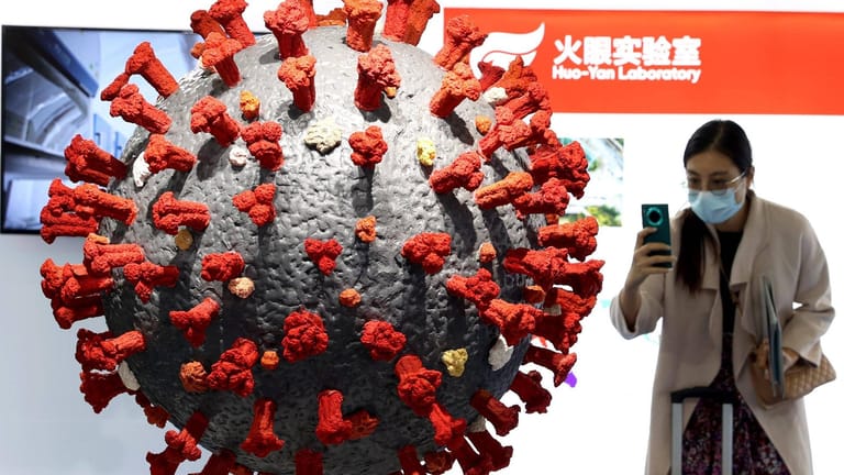 Eine Frau macht ein Foto von einem Covid-19-Modell: Etwa 4.700 Menschen starben in China bislang am Coronavirus.