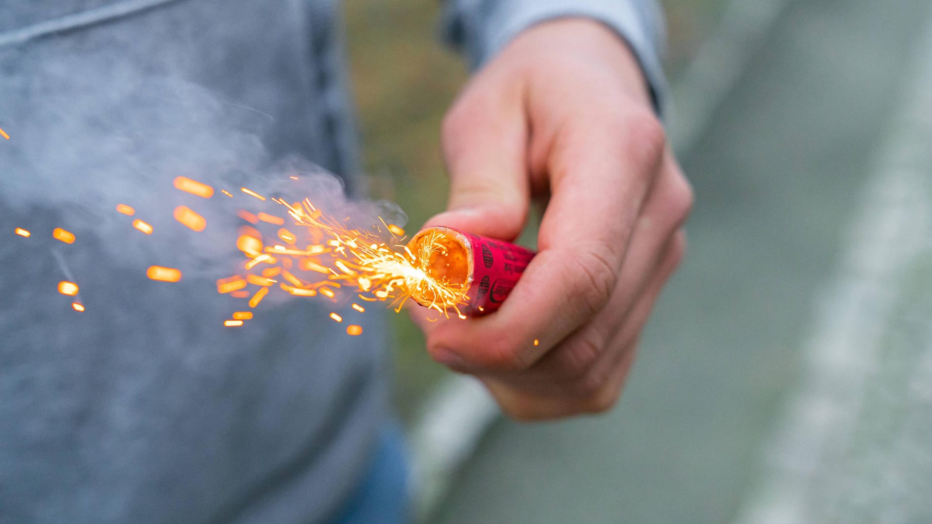 Junger Mann mit brennendem Böller in der Hand: Die Buben wurden ihren Eltern übergeben. (Symbolfoto)