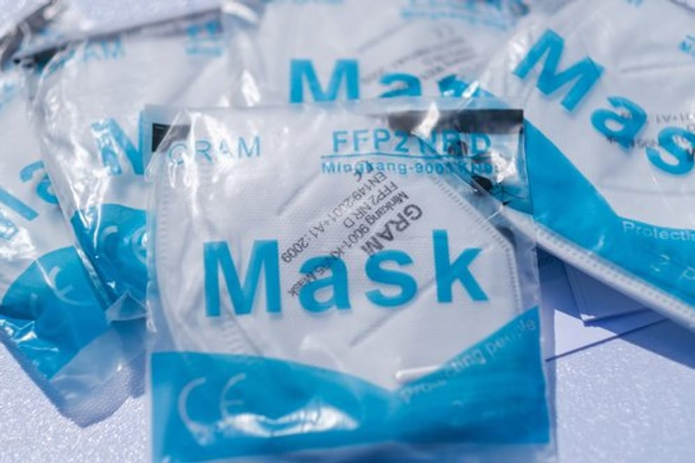 Atemschutzmasken liegen auf einem Tisch (Archivbild): In Hamburg werden gratis Masken an Schulen verteilt.