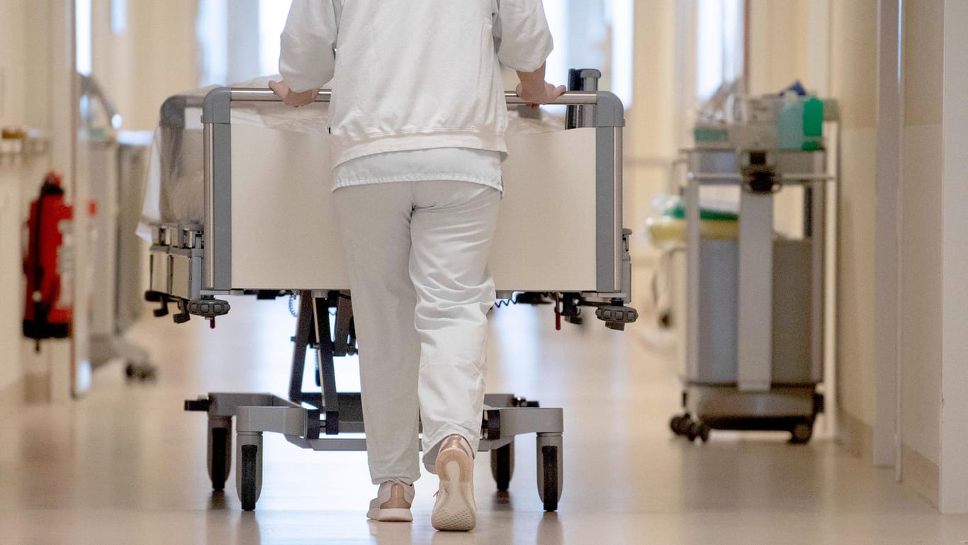 Eine Krankenpflegerin schiebt ein Krankenbett durch einen Flur (Symbolbild): Die Corona-Pandemie zehrt an den Nerven.