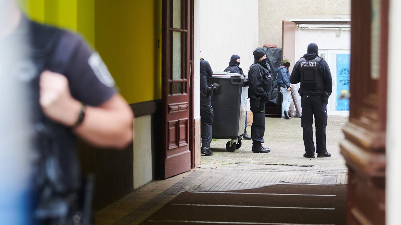 Polizisten stehen bei einem Einsatz in einem Hauseingang: Die Berliner Polizei hat Räume eines islamischen Kulturvereins in Neukölln und eine Wohnung durchsucht.