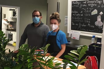 Projektleiter Sebastian Pafundi und seine Mitarbeiterin Britta Wail an der Kuchentheke des Cafés "Hier & Da" in Wuppertal: Es ist von einem Ort zur Wiedereingliederung von Arbeitslosen zu einem sozialen Treffpunkt im Viertel geworden.