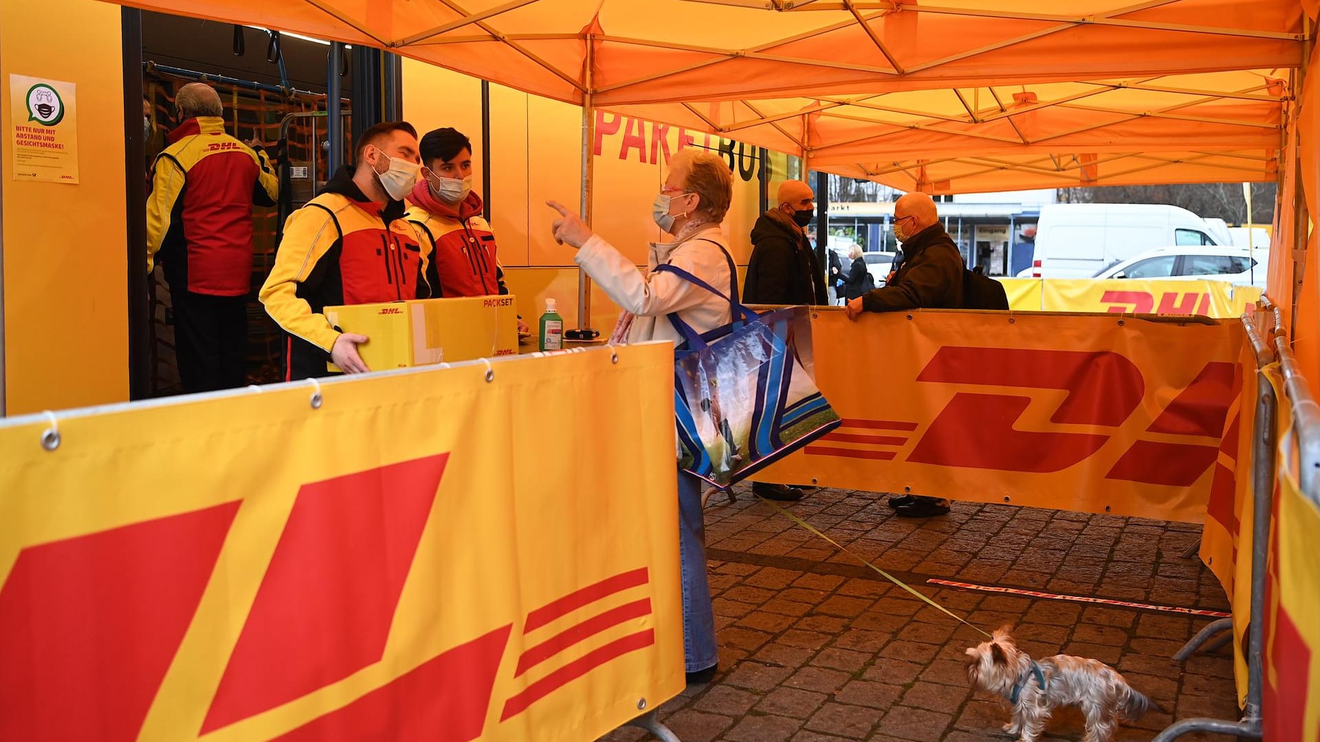 Eine Dame mit einem Hund gibt bei Mitarbeitern beim DHL-Paketbus ein Paket ab während eines Presse- und Fototermins zur Präsentation der Busse: Die Busse sollen mehrere Standorte in Berlin anfahren. Eine Dame mit einem Hund gibt bei Mitarbeitern beim DHL-Paketbus ein Paket ab während eines Presse- und Fototermins zur Präsentation der Busse: Die Busse sollen mehrere Standorte in Berlin anfahren.