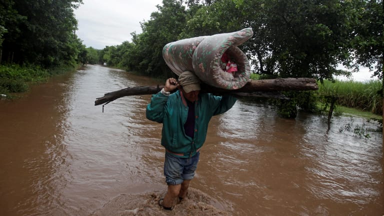 Ein Mann in Honduras trägt seine Eigentümer auf dem Kopf: Hurrikan "Iota" hat für Überschwemmungen gesorgt.