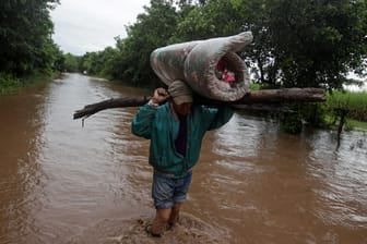 Ein Mann in Honduras trägt seine Eigentümer auf dem Kopf: Hurrikan "Iota" hat für Überschwemmungen gesorgt.