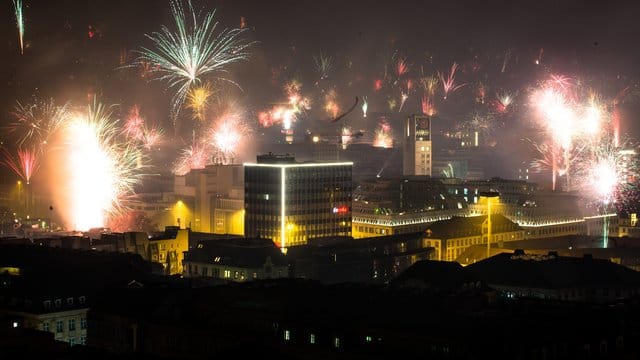 Feuerwerk wird in den nächtlichen Himmel über der Stadt abgefeuert.