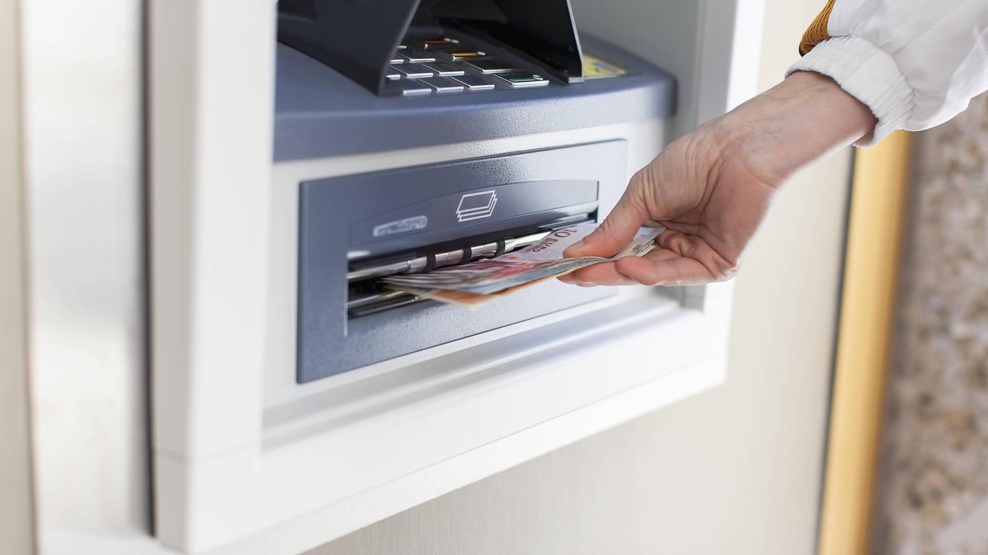 Eine Frau hebt Geld am Automaten ab (Symbolbild): In Essen überfiel ein Jugendlicher eine 91-Jährige in einer Bankfiliale.