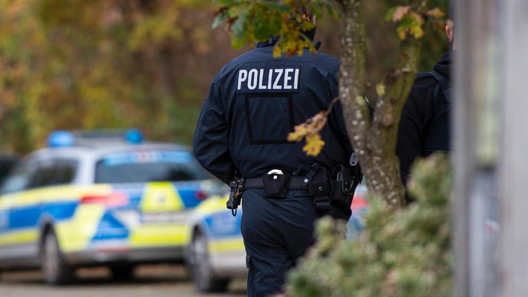 Polizisten stehen vor Einsatzfahrzeugen (Symbolbild): In Berlin wurde ein Verdächtiger in einem Totschlagsfall festgenommen.