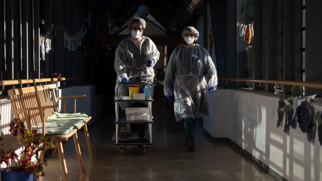 Zwei Altenpflegerinnen mit Schutzausrüstung: Die Ansteckungszahlen mit dem Coronavirus sind in Deutschland erneut auf einem Höchststand.