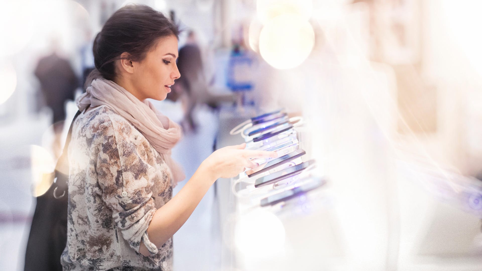 Eine Frau sieht sich Smartphone-Modelle in einem Elektronikmarkt an: Ein neues Handy kostet heute deutlich mehr als noch vor fünf Jahren. Eine Frau sieht sich Smartphone-Modelle in einem Elektronikmarkt an: Ein neues Handy kostet heute deutlich mehr als noch vor fünf Jahren.