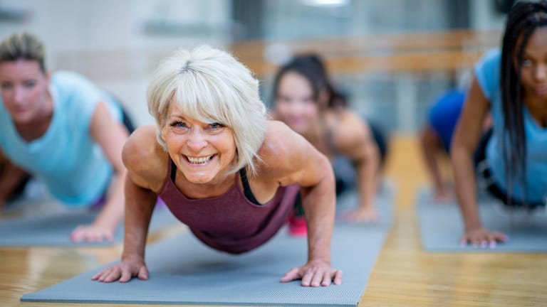 Eine Frau macht Liegestütze im Fitnessstudio: Je älter man wird, umso wichtiger ist es, durch Training und Ernährung die Knochen zu stärken.