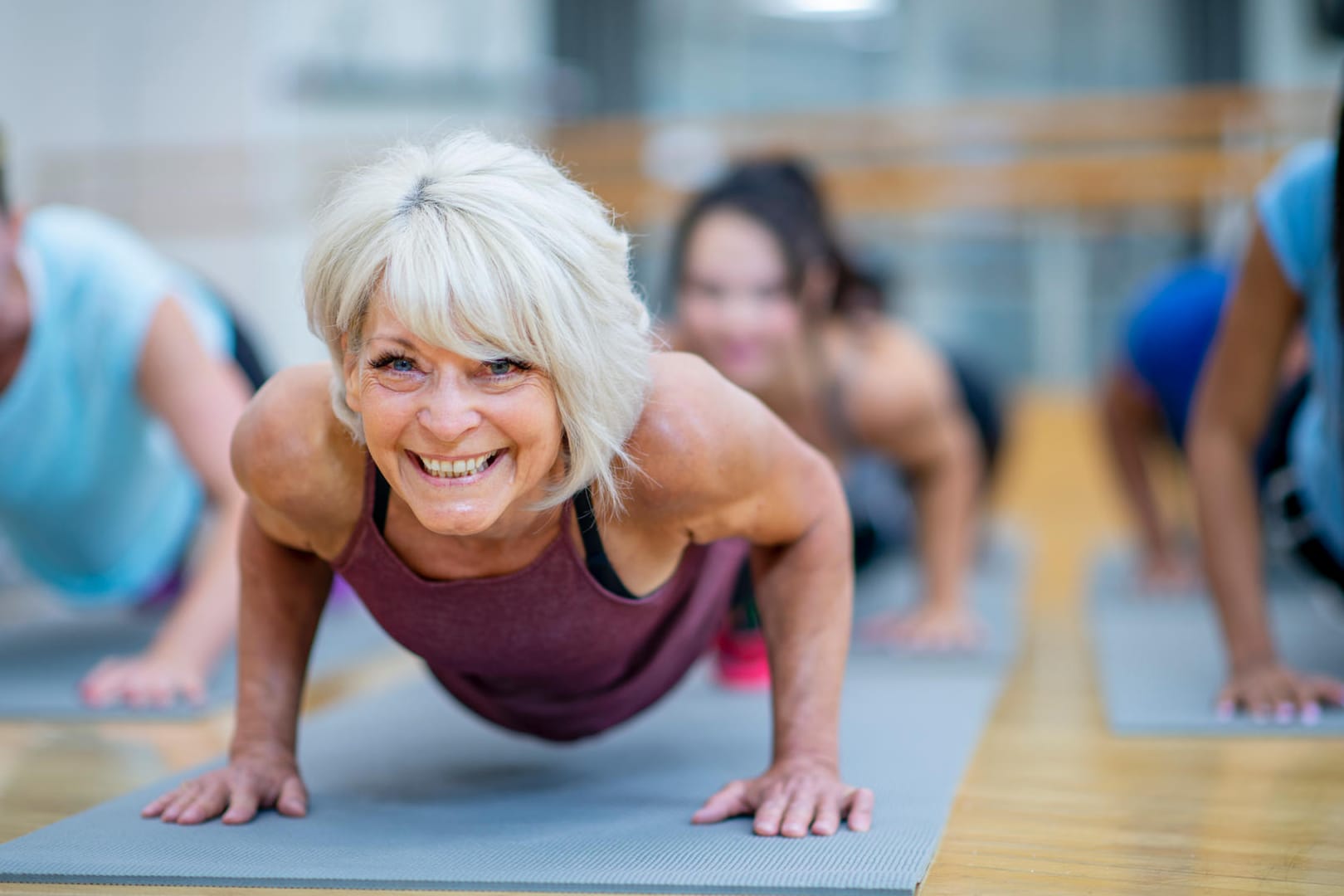 Eine Frau macht Liegestütze im Fitnessstudio: Je älter man wird, umso wichtiger ist es, durch Training und Ernährung die Knochen zu stärken.