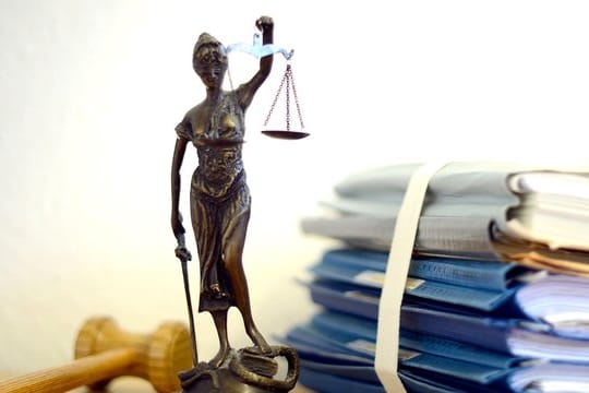 Ein Modell der Justitia steht auf einem Tisch