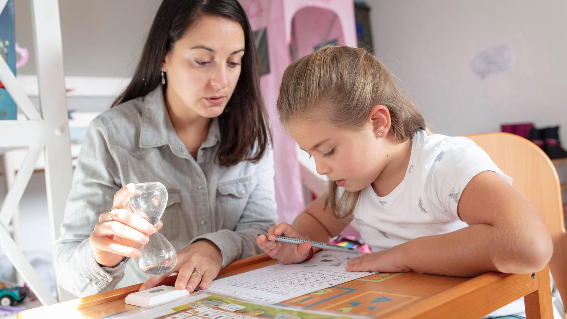 Eine Frau und ein Kind beim Lernen (Symbolbild): Für Grundschulen sucht die Stadt Essen Betreeungskräfte.