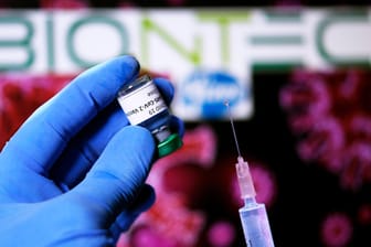 Eine Spritze und das Firmenlogo von Biontech: Die Pharmahersteller Biontech und Pfizer sind die ersten westlichen Unternehmen, die einen Antrag auf Zulassung ihres Corona-Impfstoffes gestellt haben. (Symbolfoto)