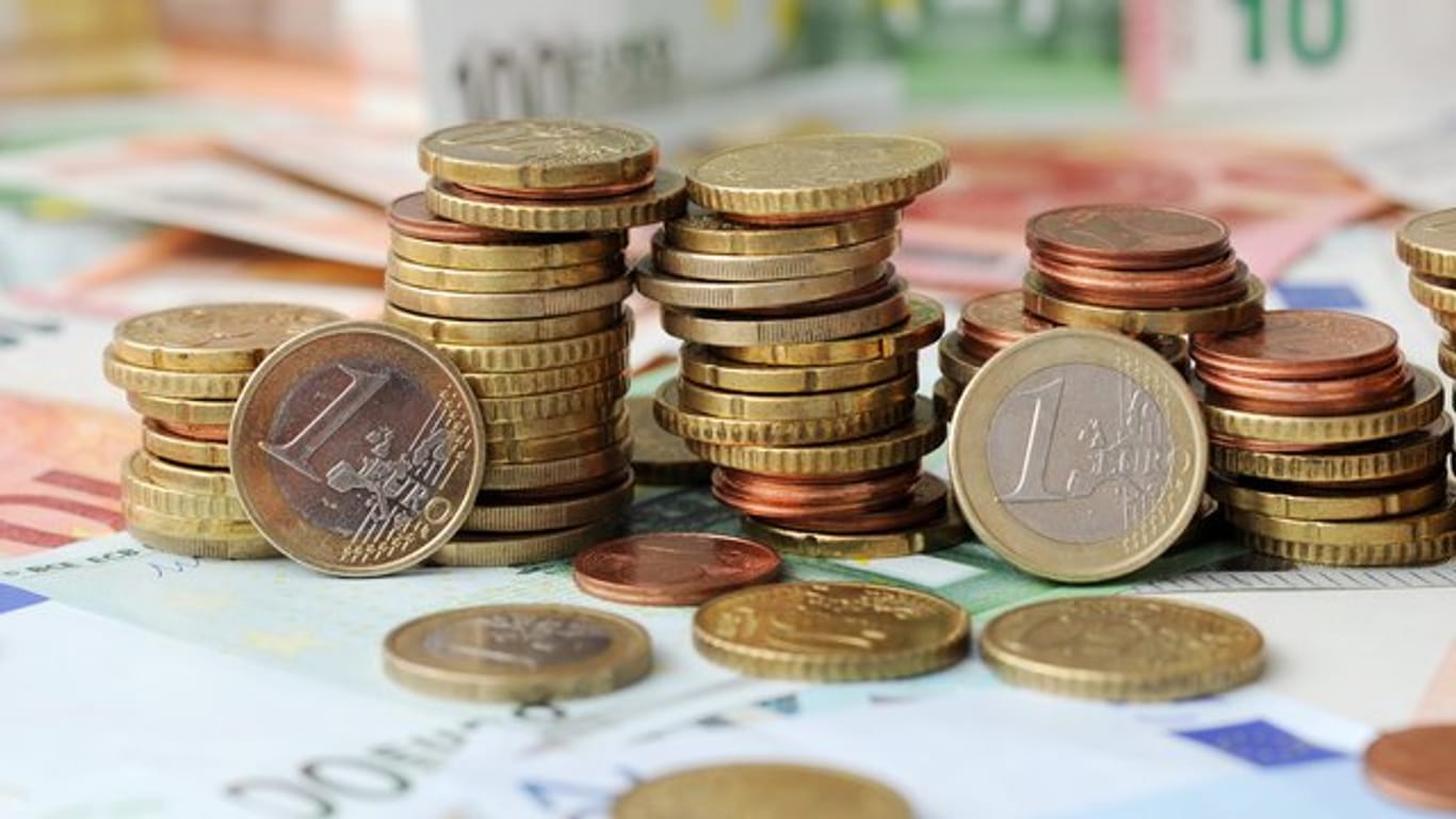 Euro-Münzen auf Euro-Banknoten: Viel Geld fließt in Hilfen für Unternehmer während der Corona-Krise.