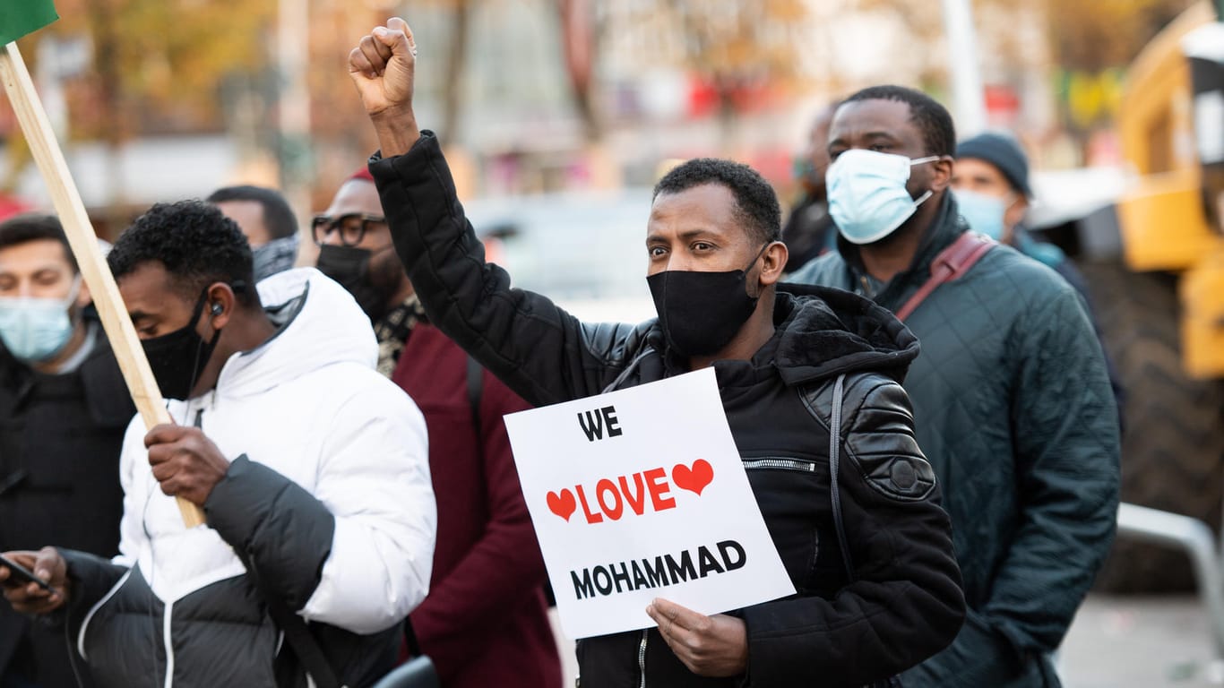 Ein Demonstrationsteilnehmer hält ein Schild mit der Aufschrift "We love Mohammad": Einem Demonstrationsaufruf von Islamisten sind in Hamburg nach Polizeiangaben bis zu 160 Menschen gefolgt.