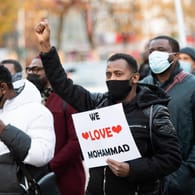 Ein Demonstrationsteilnehmer hält ein Schild mit der Aufschrift "We love Mohammad": Einem Demonstrationsaufruf von Islamisten sind in Hamburg nach Polizeiangaben bis zu 160 Menschen gefolgt.