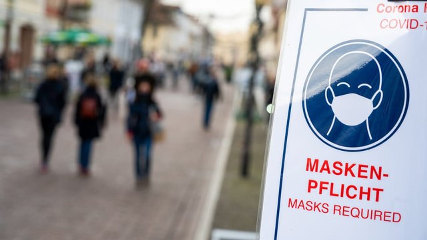 An einer Fußgängerzone steht ein Schild, dass auf die Maskenpflicht hinweist (Archivbild): Zum Rauchen darf man die Maske nicht abnehmen.