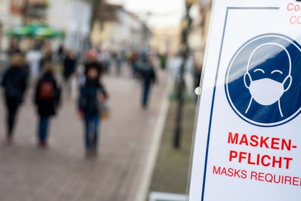 An einer Fußgängerzone steht ein Schild, dass auf die Maskenpflicht hinweist (Archivbild): Zum Rauchen darf man die Maske nicht abnehmen.