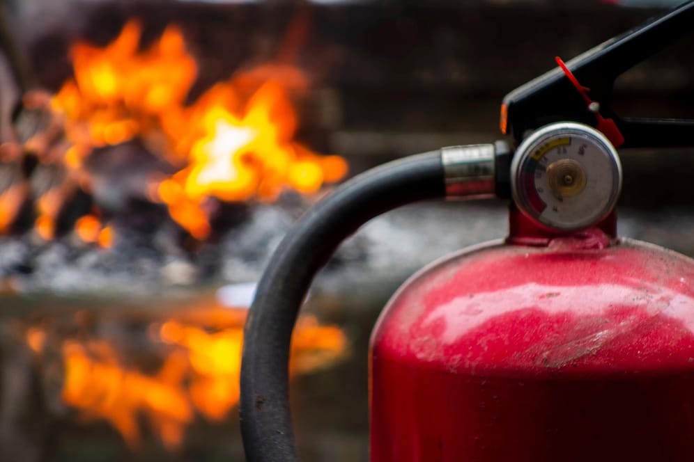 Ein Feuerlöscher steht vor einem Feuer: In Essen hat ein Mann an einer Tankstelle versucht, Benzin anzuzünden.