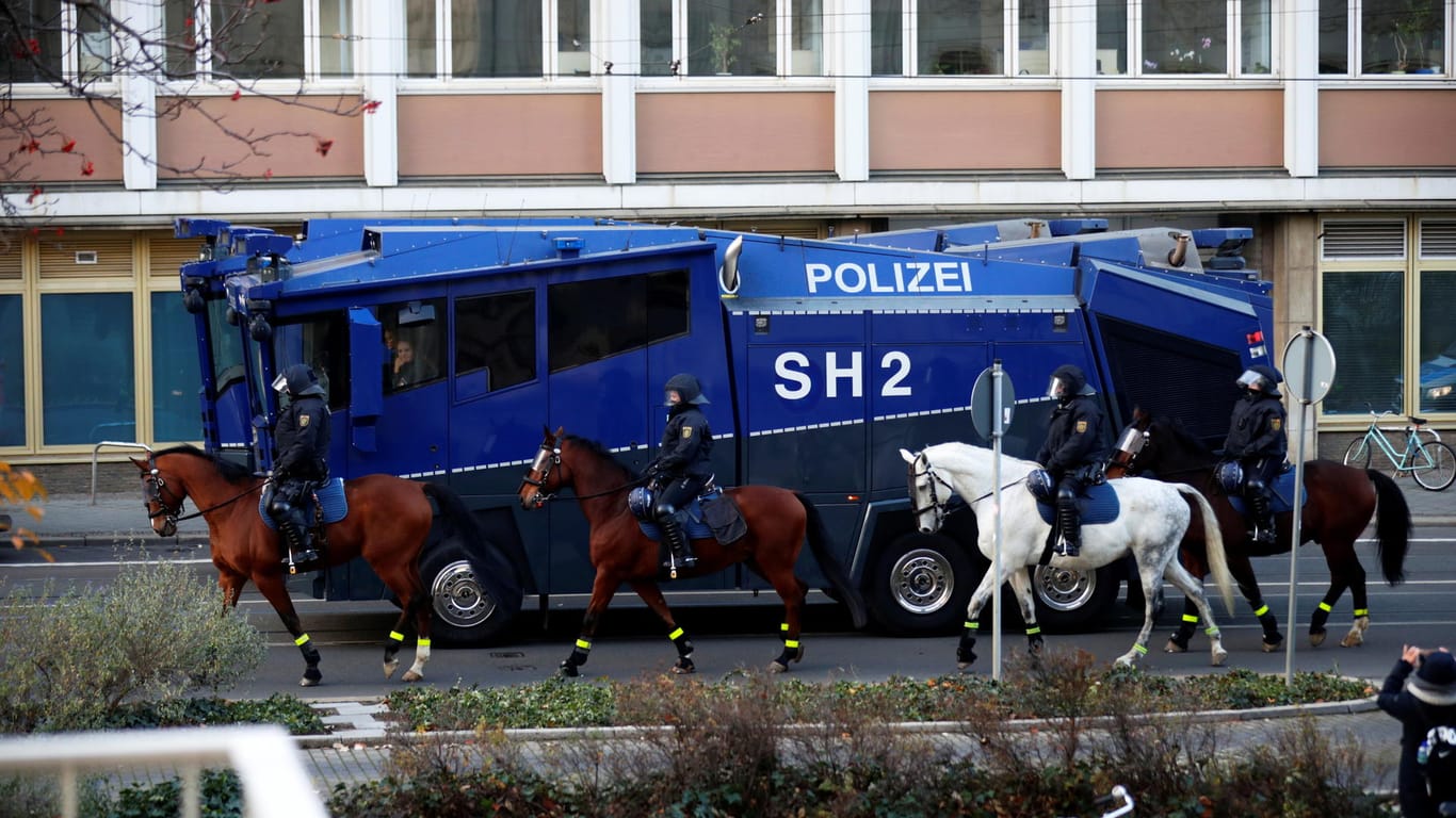 Reiter auf Pferden vor einem Fahrzeug der Polizei: In Leipzig sind viele Einsatzkräfte vor Ort.