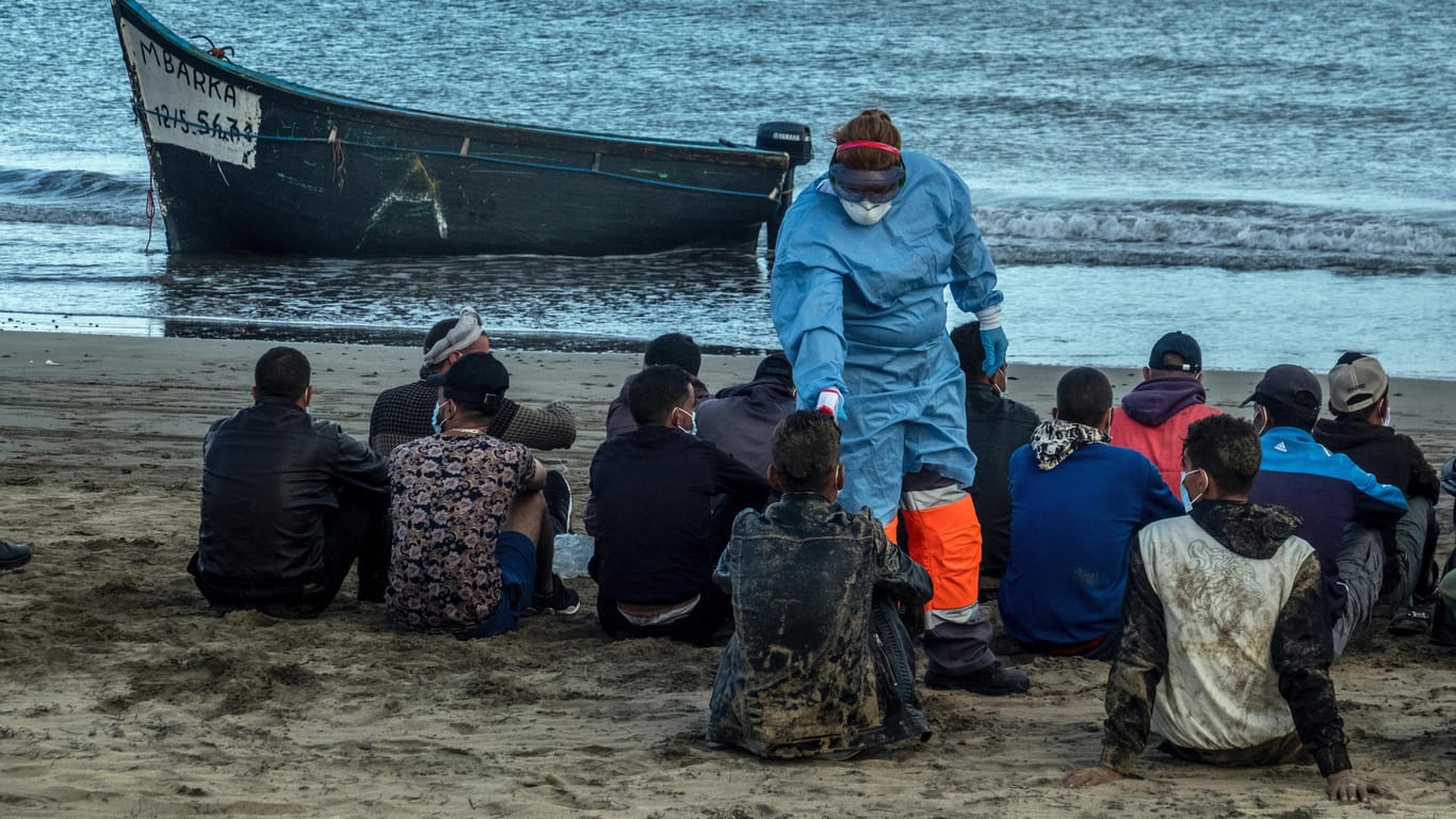 Gran Canaria: Migranten aus Marokko lassen ihre Temperatur messen, nachdem sie mit einem Holzboot an der Küste von Gran Canaria angekommen sind.