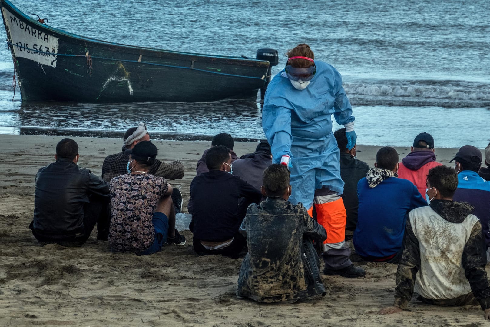 Gran Canaria: Migranten aus Marokko lassen ihre Temperatur messen, nachdem sie mit einem Holzboot an der Küste von Gran Canaria angekommen sind.