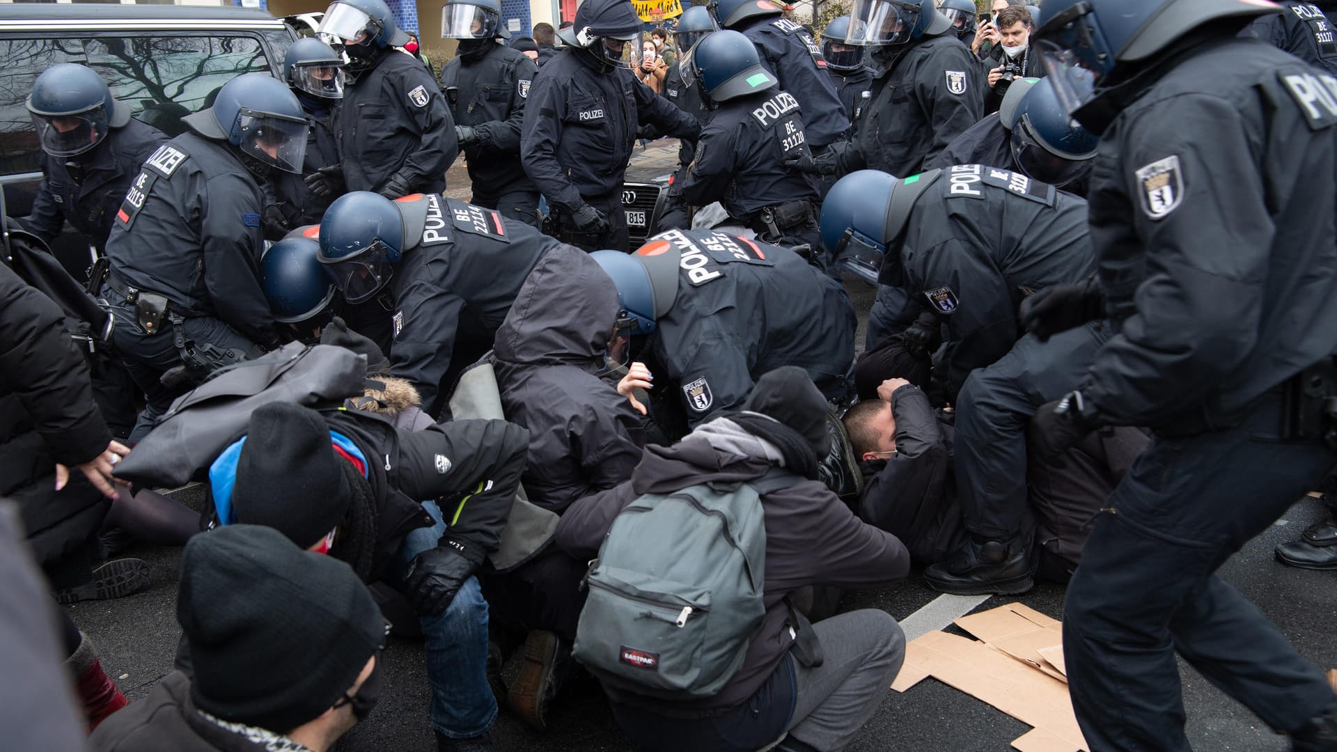 Die Polizei löst eine Sitzblockade auf: Viele Gegenprotestler haben sich in Berlin versammelt.