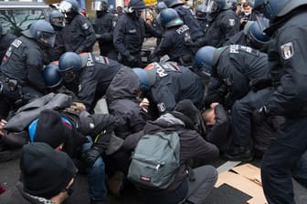 Die Polizei löst eine Sitzblockade auf: Viele Gegenprotestler haben sich in Berlin versammelt.