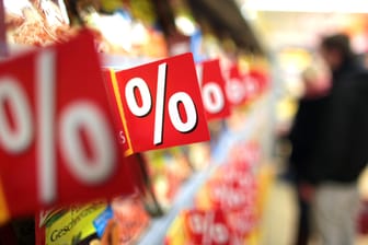 Prozentzeichen hängen in einem Supermarkt an Regalen: Im Lebensmittelhandel sind derzeit wieder einige Artikel rabattiert.