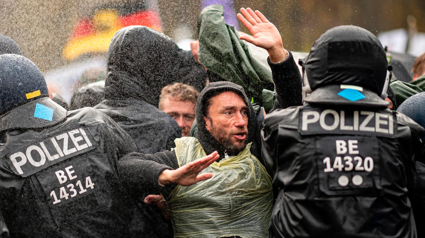 18.11.2020, Berlin: Die Polizei drängt die Teilnehmer der Demonstration gegen die Corona-Einschränkungen der Bundesregierung vor dem Brandenburger Tor mit Wasserwerfern zurück.
