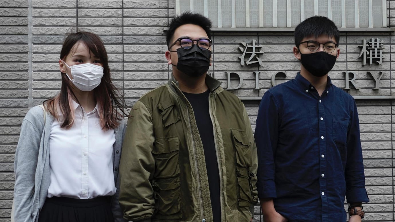 Agnes Chow, Ivan Lam und Joshua Wong vor dem Gerichtsgebäude: Alle drei Aktivisten plädieren zum Prozessauftakt auf schuldig. Agnes Chow, Ivan Lam und Joshua Wong vor dem Gerichtsgebäude: Alle drei Aktivisten plädieren zum Prozessauftakt auf schuldig.