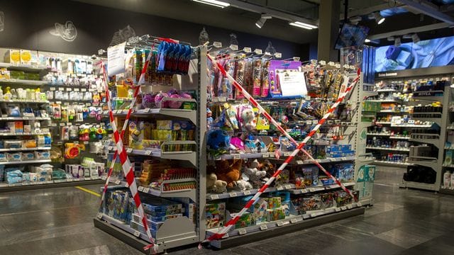 Ein Regal mit Spielzeug, also nicht-essentiellen Waren, ist in einem Genfer Supermarkt mit Flatterband abgesperrt. Ein Regal mit Spielzeug, also nicht-essentiellen Waren, ist in einem Genfer Supermarkt mit Flatterband abgesperrt.
