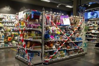 Ein Regal mit Spielzeug, also nicht-essentiellen Waren, ist in einem Genfer Supermarkt mit Flatterband abgesperrt.
