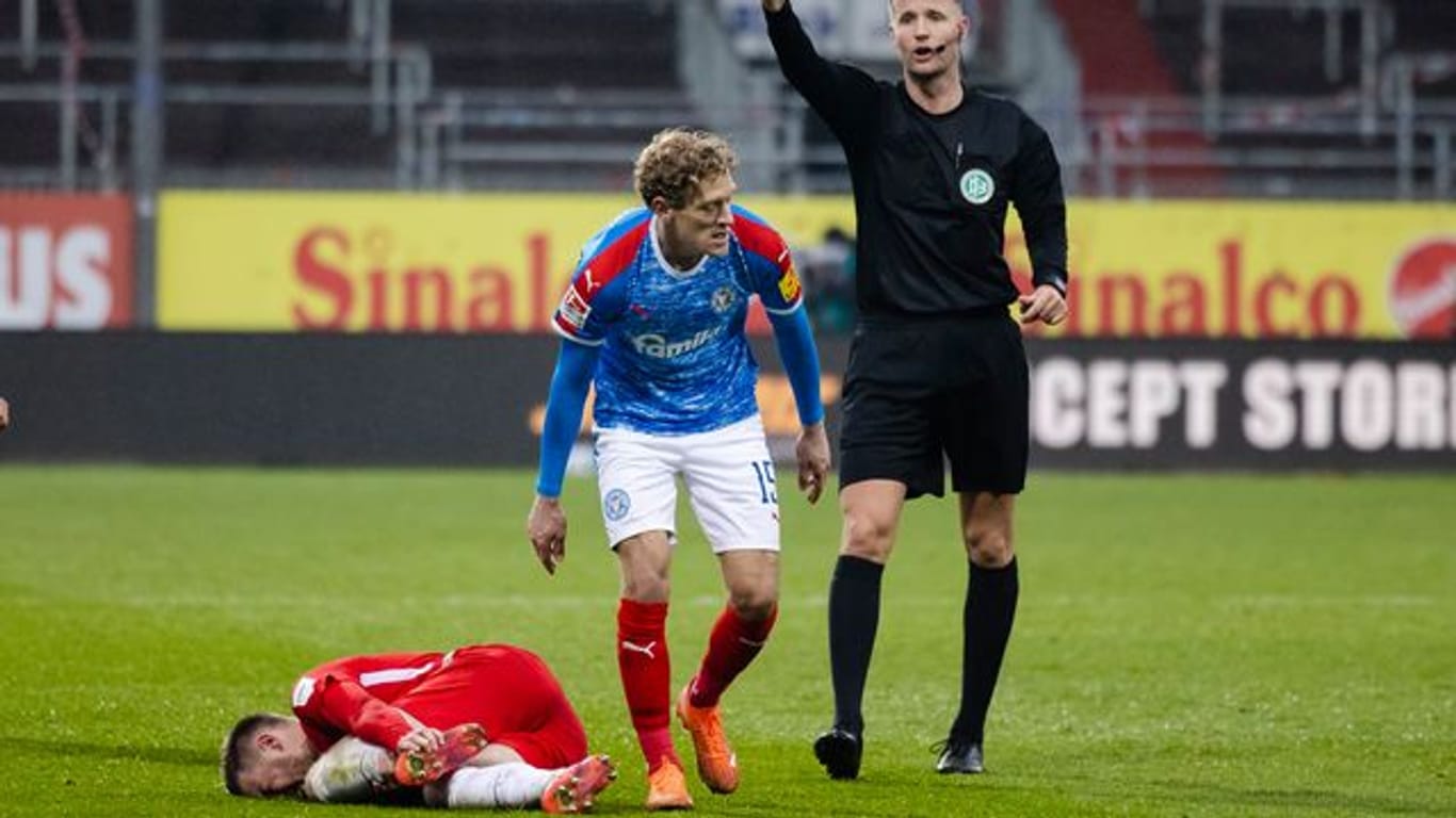 Nach einem Foul an Christian Kühlwetter (l), zeigt Schiedsrichter Arne Aamink (r) Kiels Johannes van den Bergh die Rote Karte.
