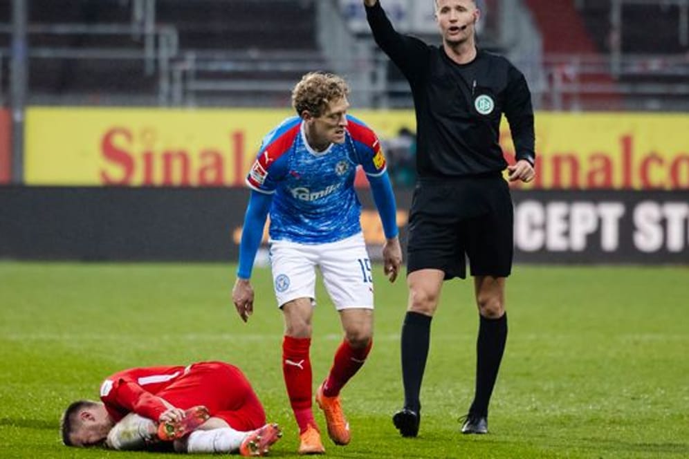 Nach einem Foul an Christian Kühlwetter (l), zeigt Schiedsrichter Arne Aamink (r) Kiels Johannes van den Bergh die Rote Karte.