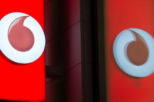Das Logo von Vodafone spiegelt sich in der Fensterscheibe einer Verkaufsfiliale des Unternehmens.