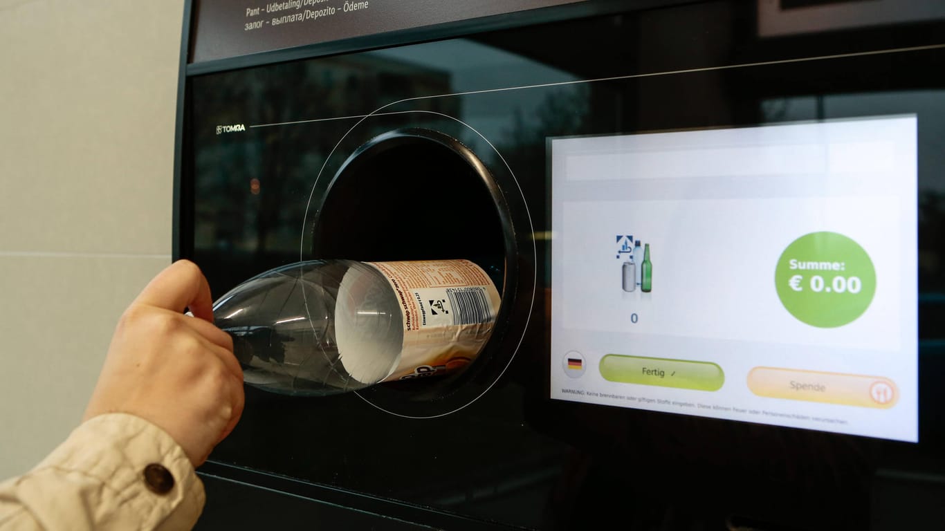 Eine Person wirft eine Flasche in einen Pfandautomaten (Symbolbild): Ein Firmenchef hat mit manipulierten Pfandautomaten einen Millionenbetrug begangen.