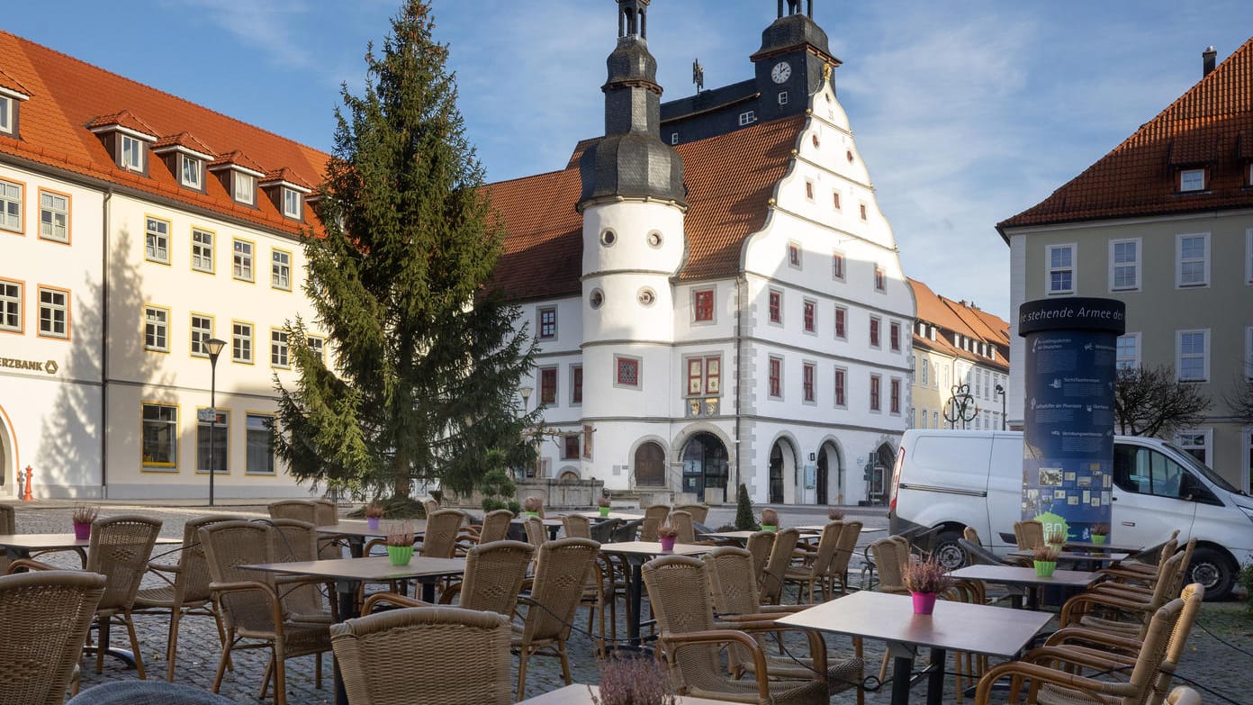 Hildburghausen: Leere Stühle stehen vor einem Cafe vor dem Rathaus. Das Infektionsgeschehen in der Corona-Pandemie hat im Landkreis Hildburghausen einen bundesweiten Höchststand erreicht.