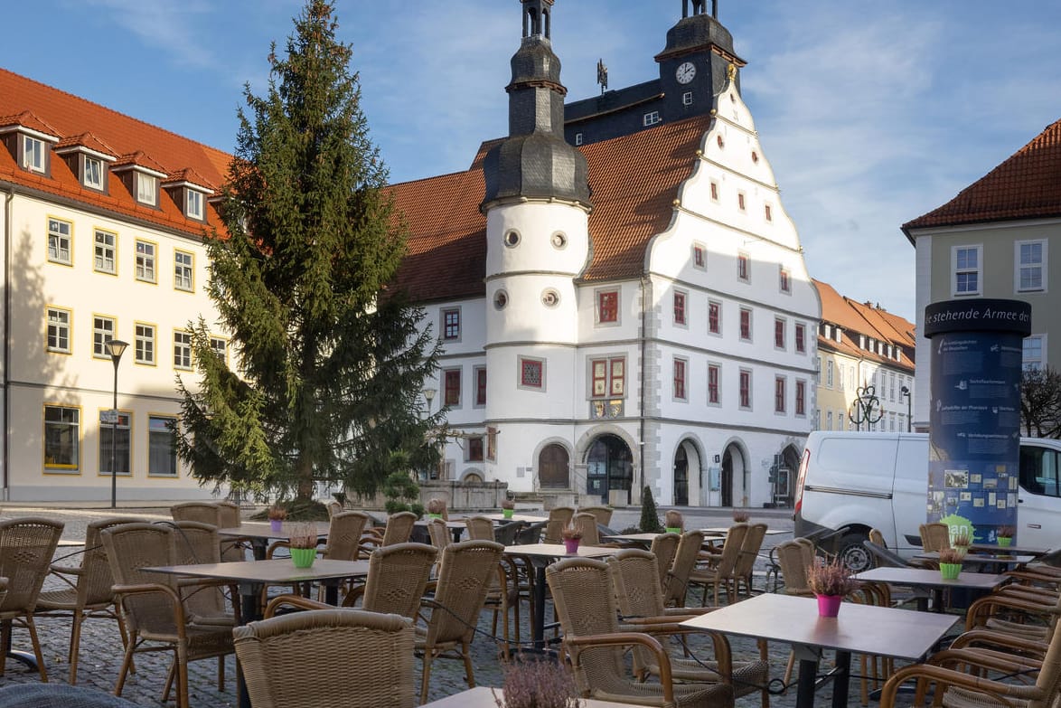 Hildburghausen: Leere Stühle stehen vor einem Cafe vor dem Rathaus. Das Infektionsgeschehen in der Corona-Pandemie hat im Landkreis Hildburghausen einen bundesweiten Höchststand erreicht.